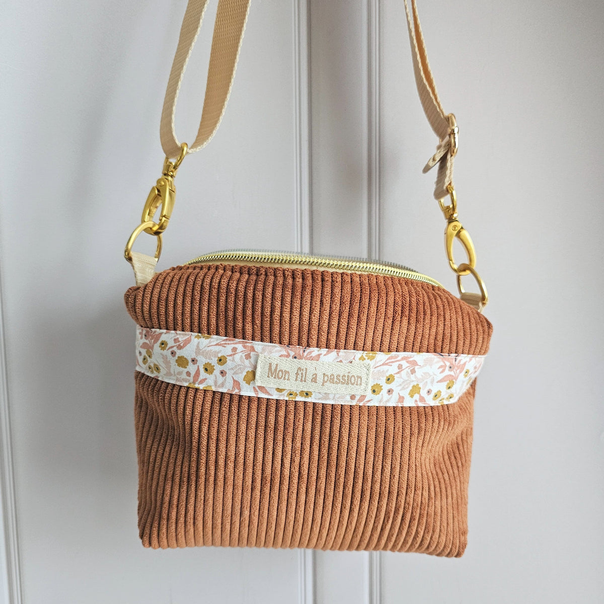 Sac bandoulière pour appareil TENS avec une encoche arrière pour le passage des câbles. Modèle velours camel et coton fleuris rose et moutarde