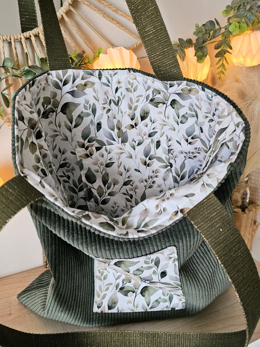 Grand sac tote bag artisanal en velours kaki et coton motif boisé, posé sur une table pour montrer sa souplesse et sa légèreté 