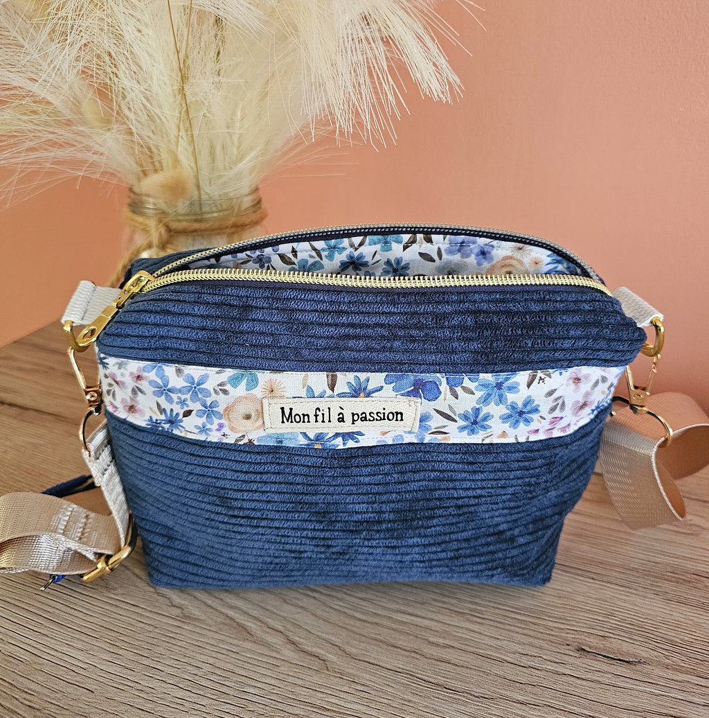 Sac bandoulière pour porter son TENS avec discrétion et liberté des mouvements. Moins de gêne des câbles de l'appareil d'éléctroneurostimulation. Sac en velours côtelé couleur bleu denim et motif fleuris 