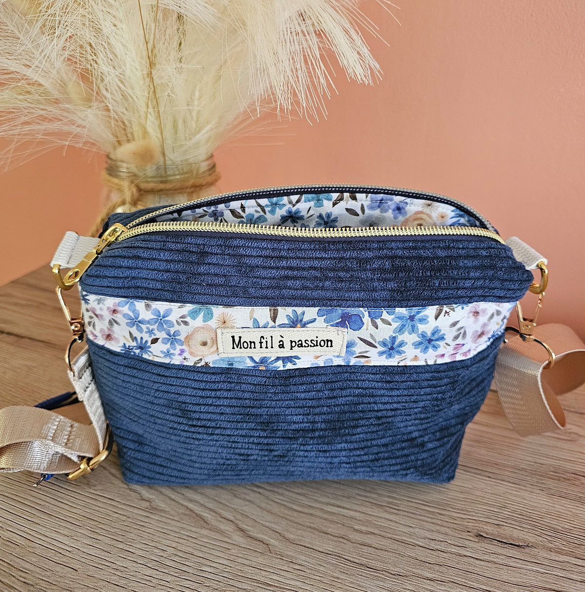 Sac bandoulière pour porter son TENS avec discrétion et liberté des mouvements. Moins de gêne des câbles de l'appareil d'éléctroneurostimulation. Sac en velours côtelé couleur bleu denim et motif fleuris 