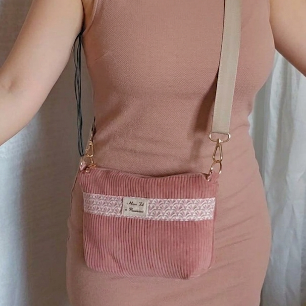 Sac bandoulière porté par une femme en robe est rangée son appareil TENS à l'intérieur les câbles sont peu visible et la femme bouge sans être gênée 