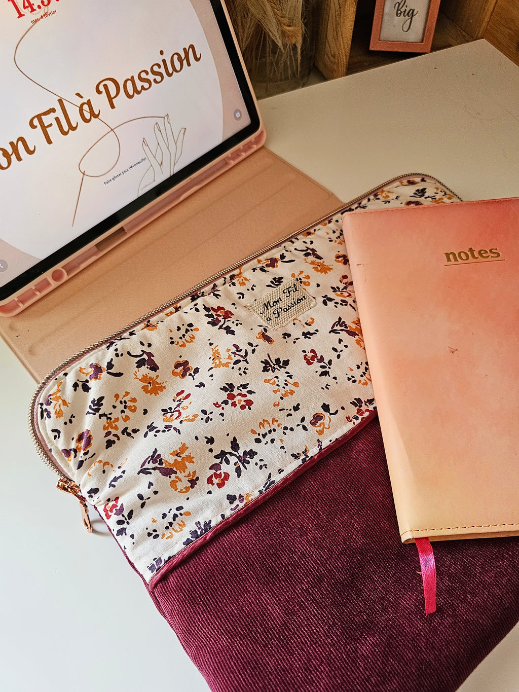 Housse de tablette ou iPad posé sur un bureau avec le nécessaire pour le travail. Housse en velours bordeau et coton imprimé petites fleurs 