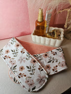 Bandeau de soin du visage en éponge de bambou corail et coton oeko tex aux motifs fleurs dans les tons beige rosé, rose. Le bandeau de soin se fixe à l'aide d'un scratch/velcro. Accessoire pour routine beauté fait main