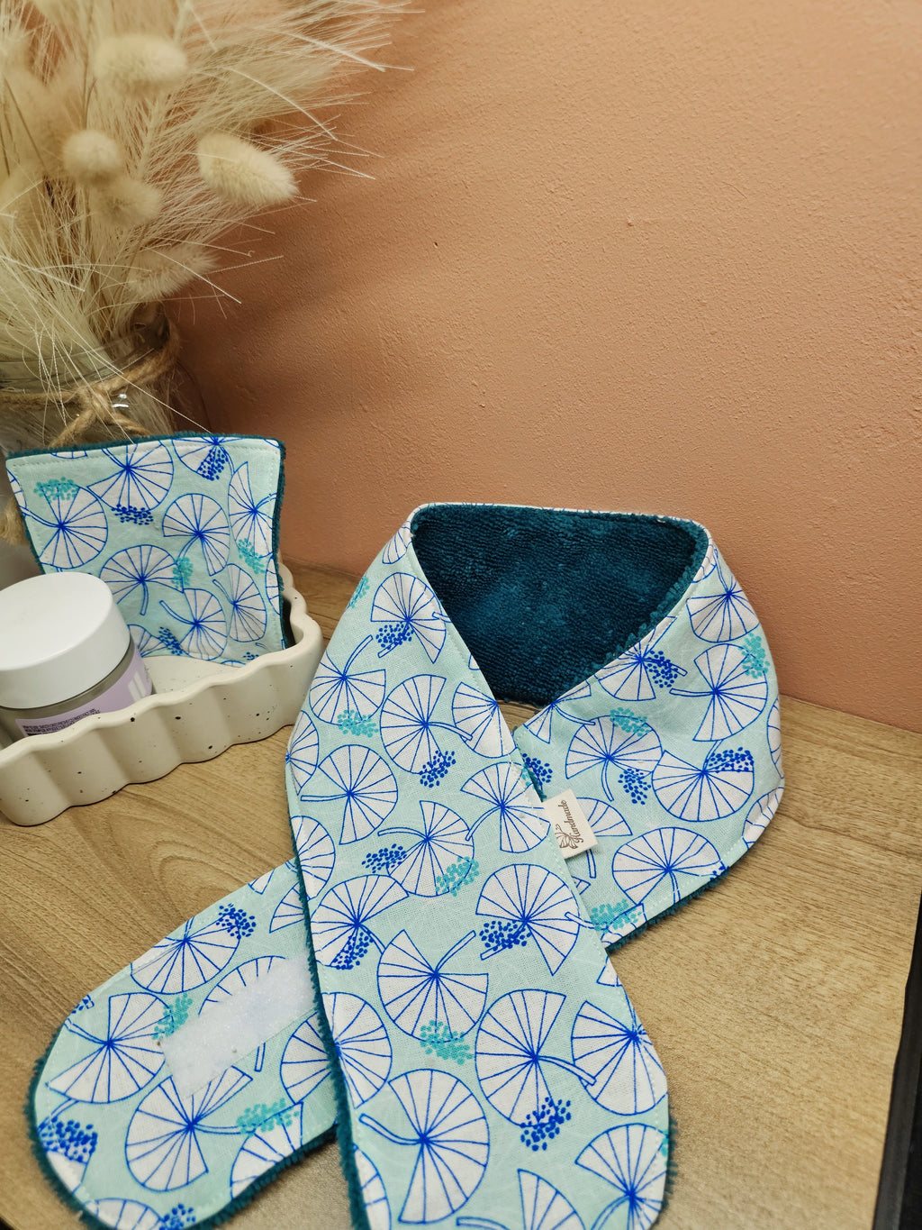 Bandeau de soin du visage en éponge de bambou vert émeraude et coton oeko tex aux motifs nénuphars bleu canard et vert d'eau. Le bandeau se fixe à l'aide d'un scratch/velcro. Accessoire pour routine beauté fait main