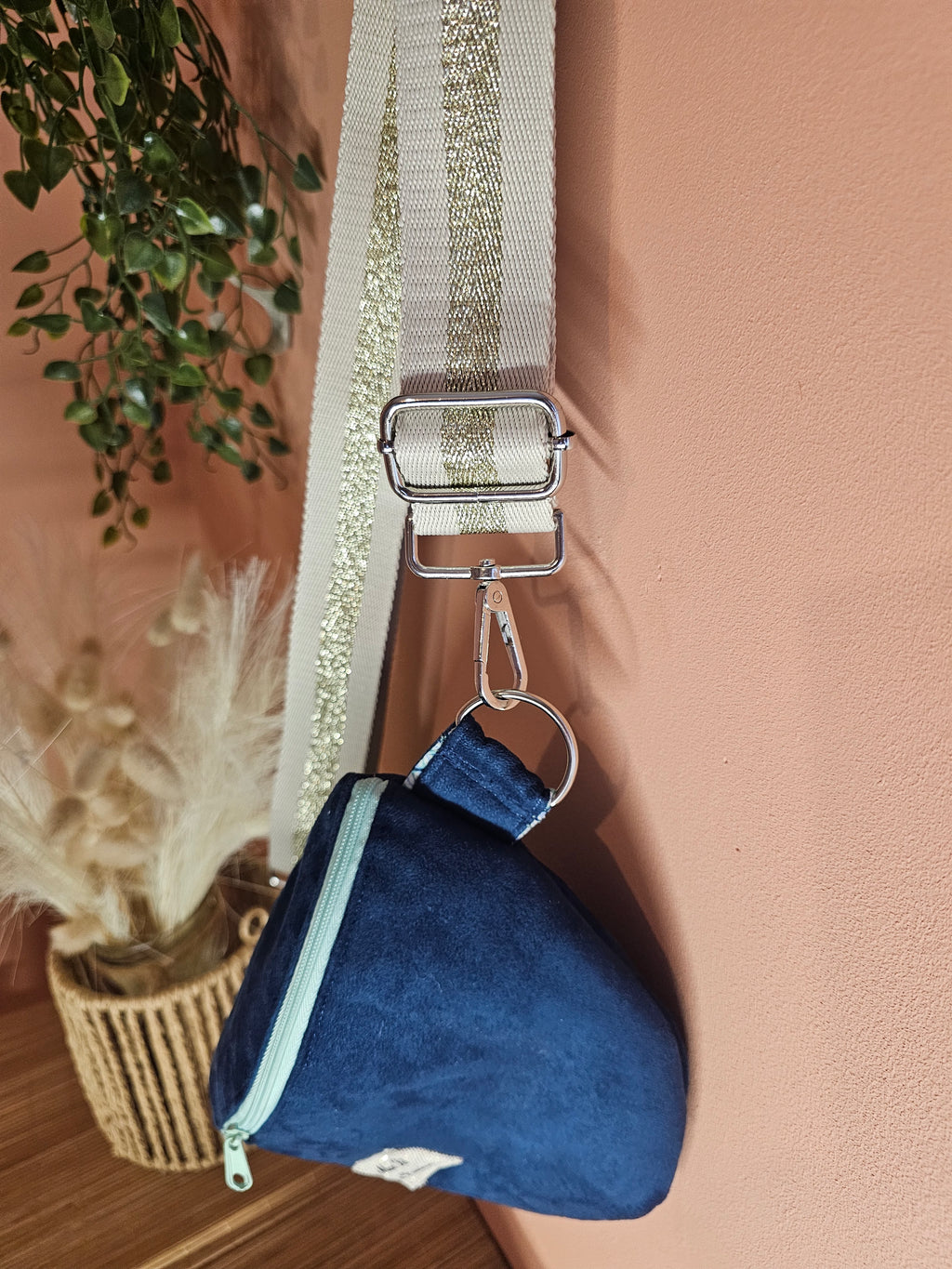 détail du sac banane avec les anneaux et mousquetons couleur argentée. finition avec une surpiqûre ton sur ton