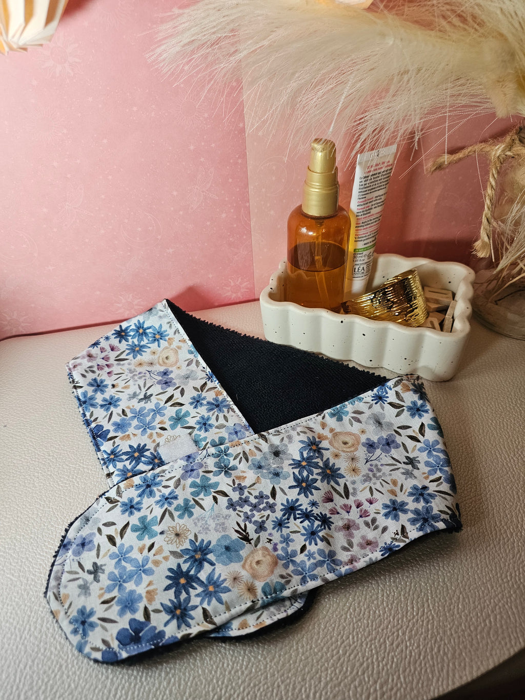 Bandeau de soin du visage en éponge de bambou bleu marine et coton oeko tex blanc aux motifs fleuries dans les tons ocre, bleu. Le bandeau se fixe à l'aide d'un scratch/velcro. Accessoire pour routine beauté fait main