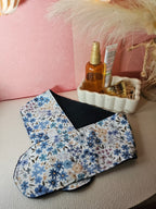 Bandeau de soin du visage en éponge de bambou bleu marine et coton oeko tex blanc aux motifs fleuries dans les tons ocre, bleu. Le bandeau se fixe à l'aide d'un scratch/velcro. Accessoire pour routine beauté fait main