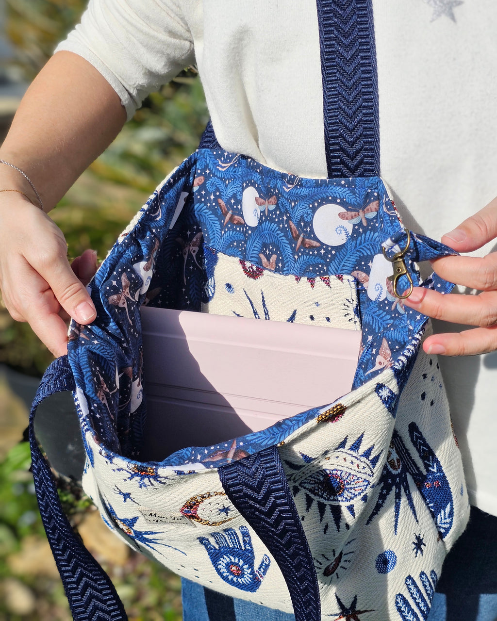 Vue intérieure d'un sac cabas avec doublure coton motifs mystique,  papillondenuit et pleinelune, poche plaquée et mousqueton porte-clés.