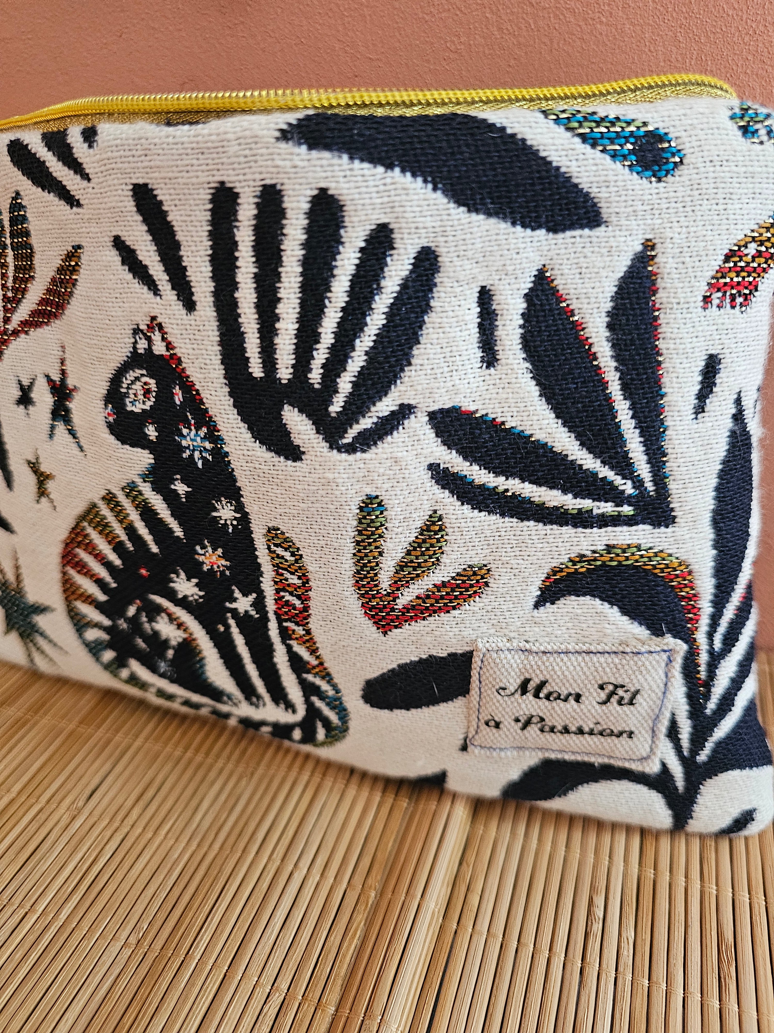 Zoom sur le tissus en jacquard très épais, magnifique pochette aux motifs chats  et symboles égyptien et l'étiquette de la marque  Mon Fil à Passion 